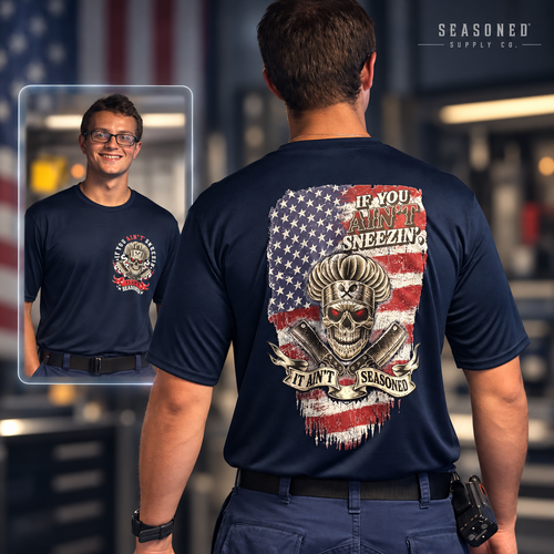 Seasoned Performance Tee dry-fit sample with American flag and skull-chef back artwork and front-chest graphic shown in a glass inset.