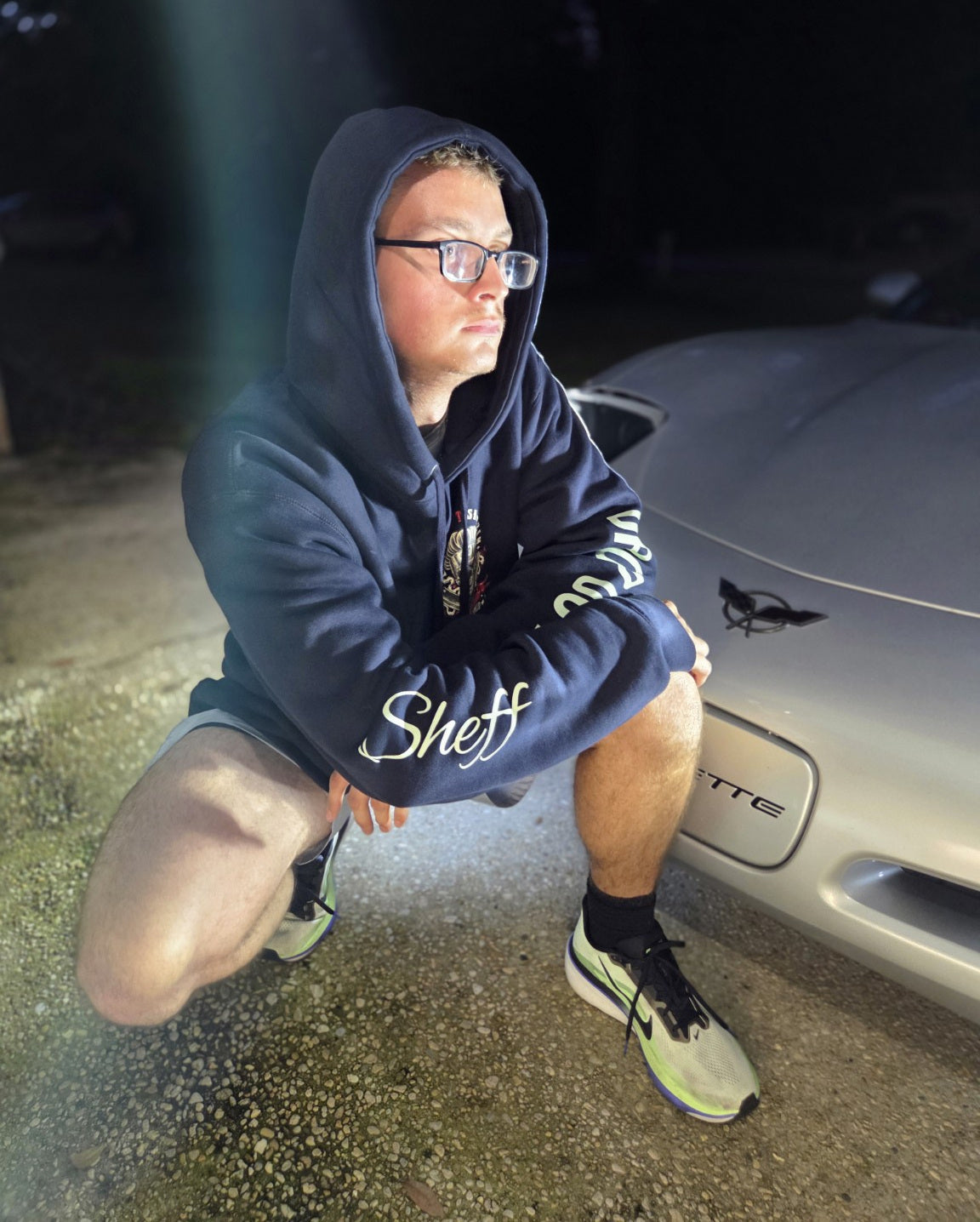 OG hoodie personal sample photographed at night beside a silver car. Personalized sleeve names are not included.