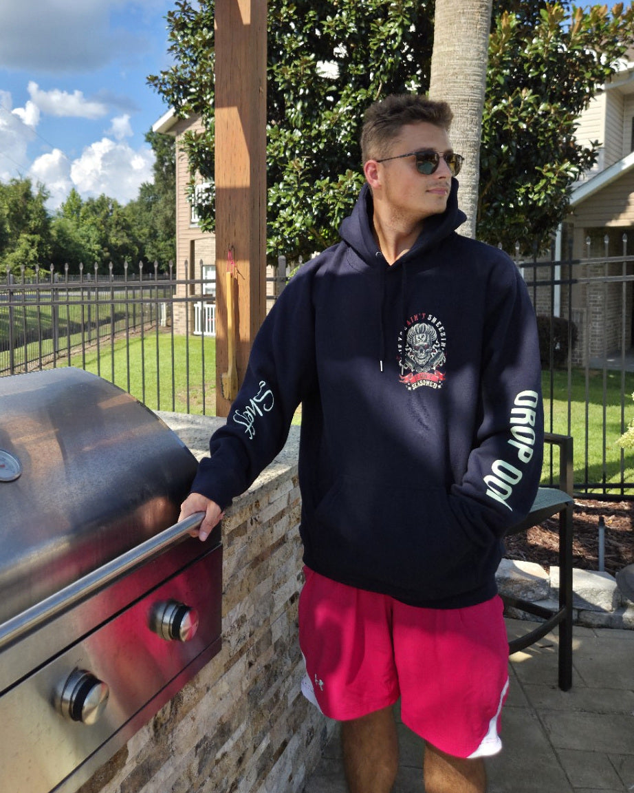 OG hoodie personal sample photographed beside an outdoor grill. Personalized sleeve names are not included.